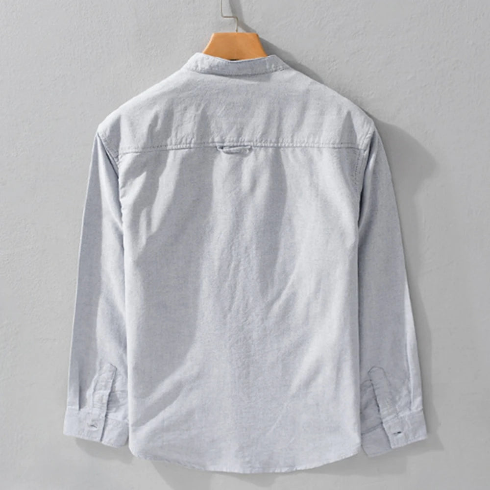 Light gray shirt on a wooden hanger against a gray background