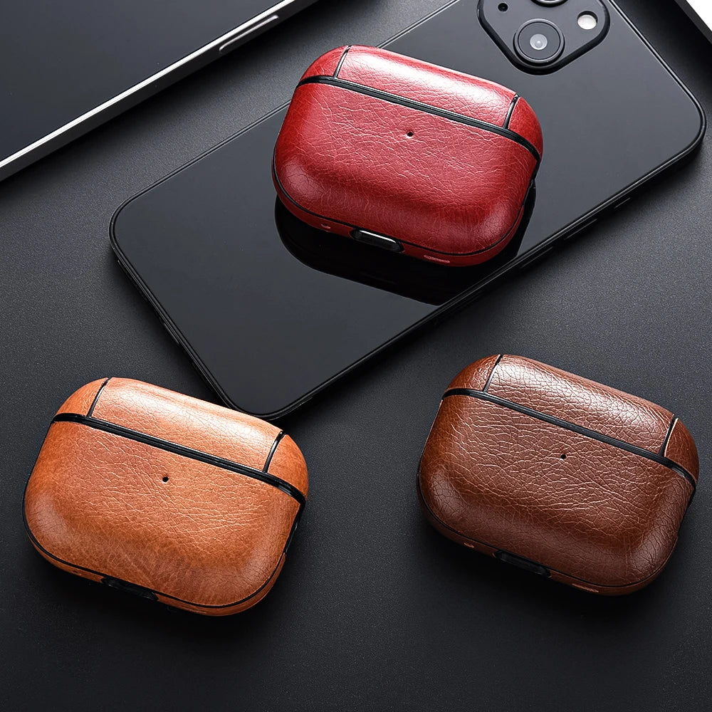 Three leather cases in red, brown, and black on a black surface with a phone.