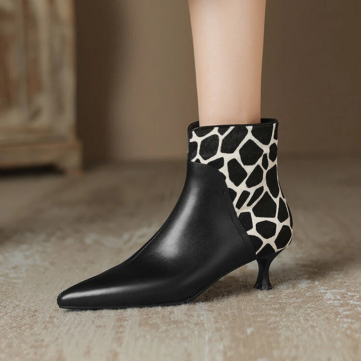 Black ankle boot with giraffe patterned heel on a neutral background