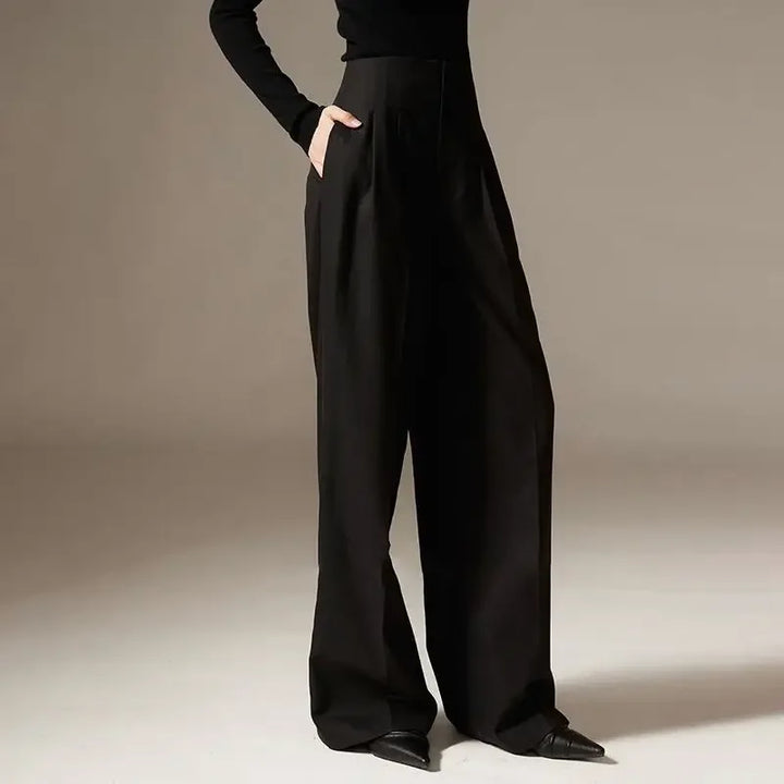 Person wearing black wide-leg pants on a neutral background
