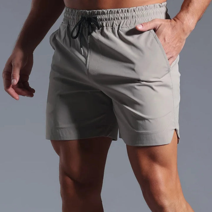 Gray athletic shorts worn by a person on a gray background