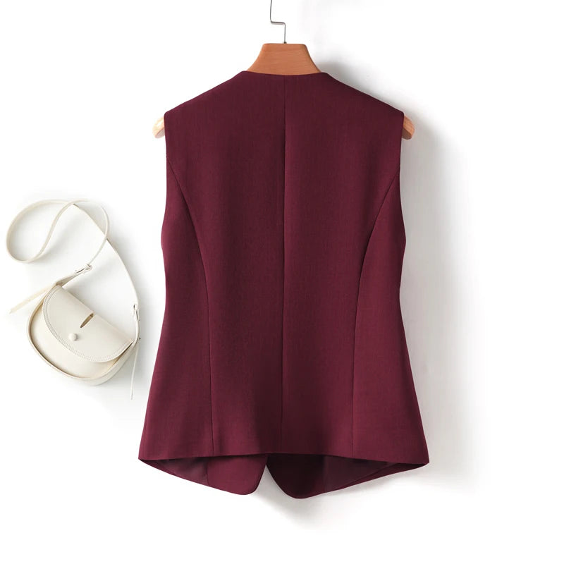 Maroon vest on a hanger with a white handbag on a white background