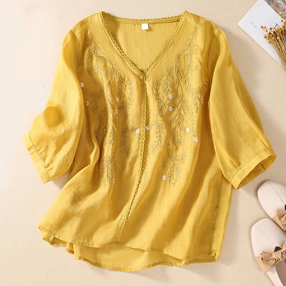 Yellow blouse with floral embroidery on a beige background