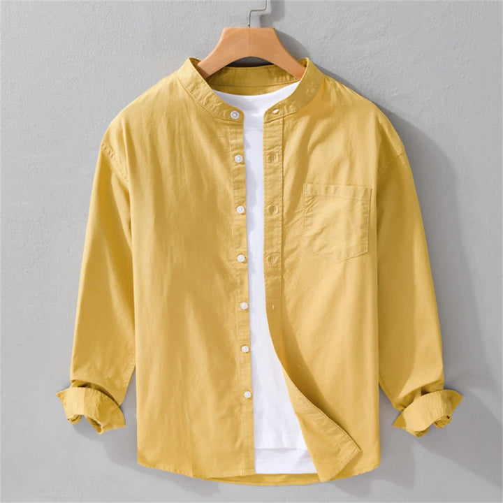 Yellow shirt on a hanger against a gray background