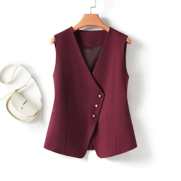 Maroon vest on a wooden hanger with a white background