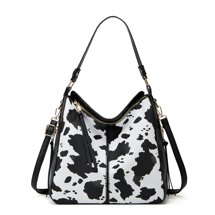Black and white cow print handbag on a white background