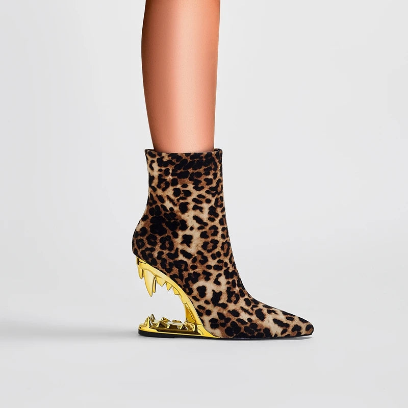 Leopard print ankle boot with gold heel on a light gray background