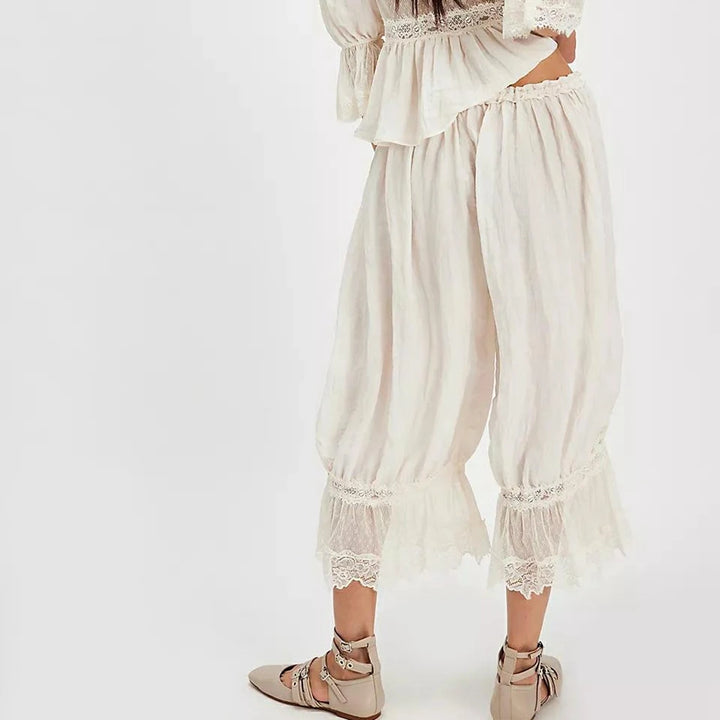 White lace-trimmed dress with matching pants on a white background