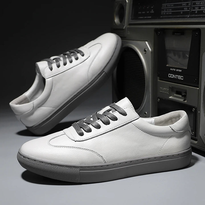White sneakers with gray laces on a dark surface with an old-style radio in the background.