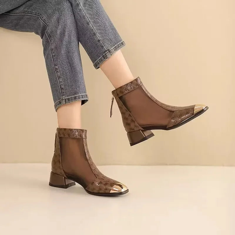 Brown open-toe ankle boots worn with rolled-up jeans on a beige background