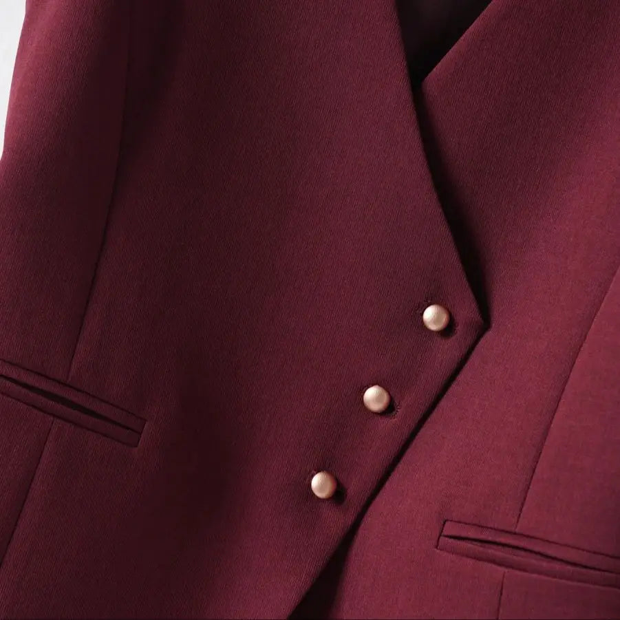 Close-up of a burgundy suit jacket with two buttons on a light gray background