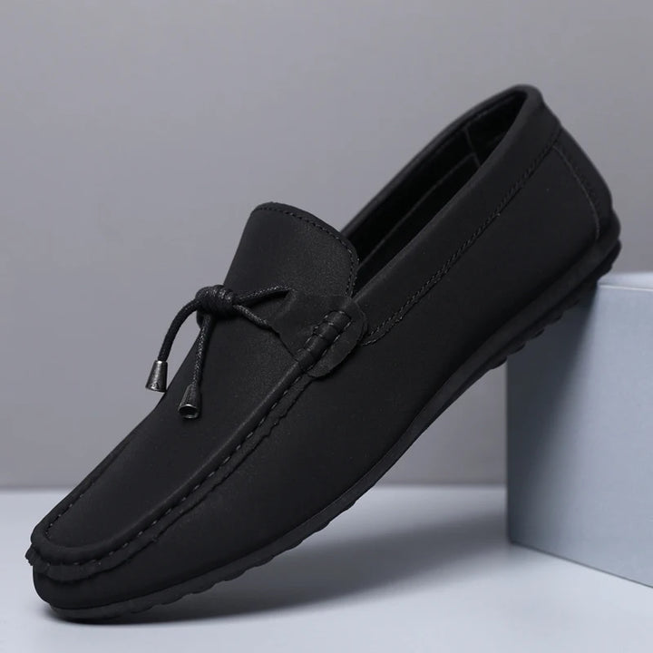 Black loafer shoe on a light gray background