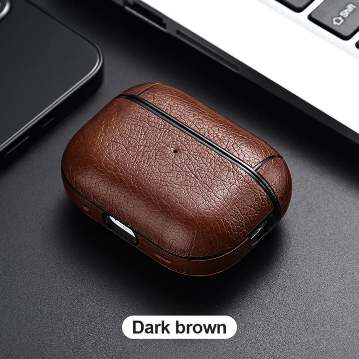 Dark brown leather case on a dark surface with a blurred laptop and phone in the background.