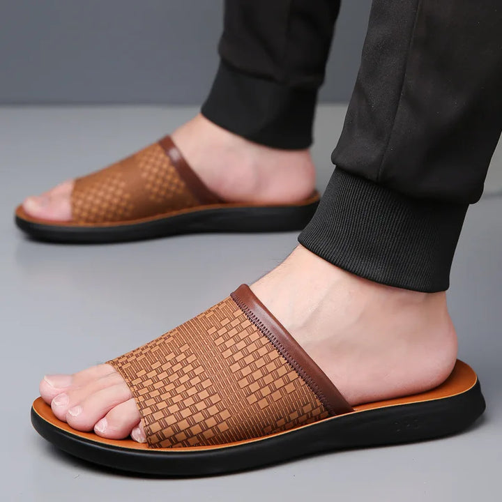 Brown woven sandals worn by a person on a gray background