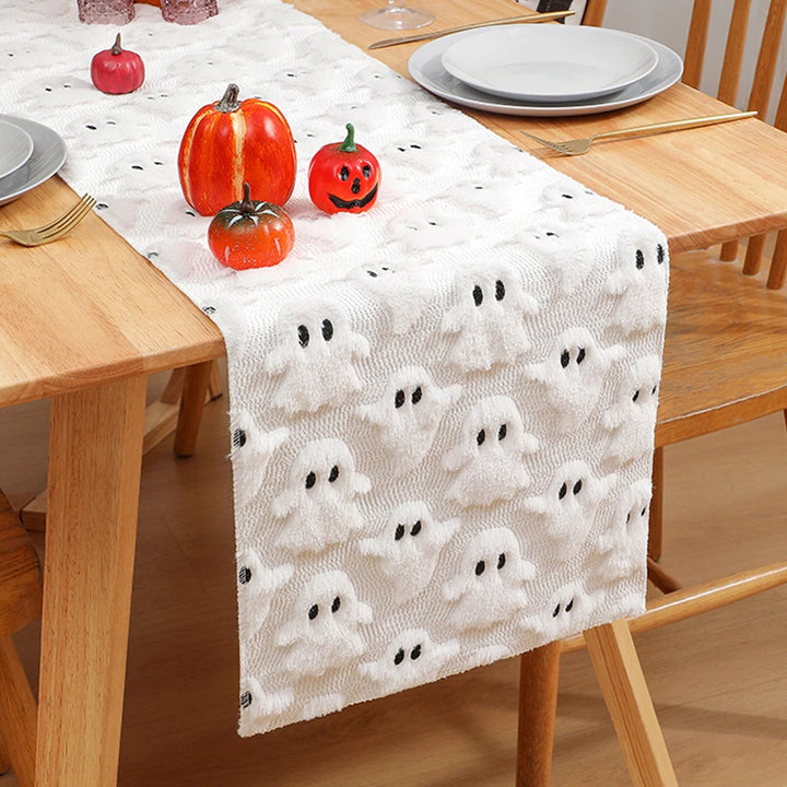 Halloween-themed table runner with ghost pattern on a wooden table.