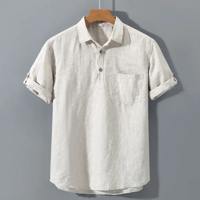 Light-colored short-sleeve shirt on a hanger against a gray background