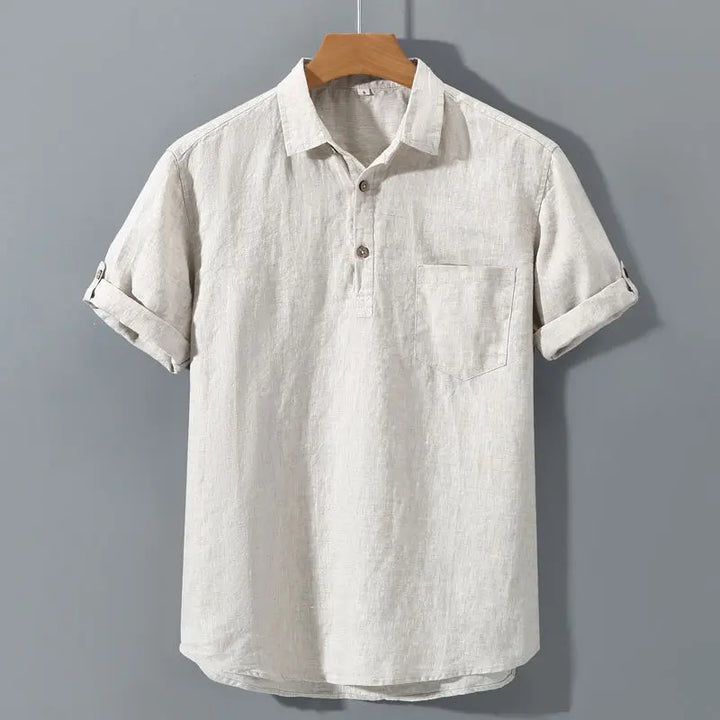 Light-colored short-sleeve shirt on a hanger against a gray background