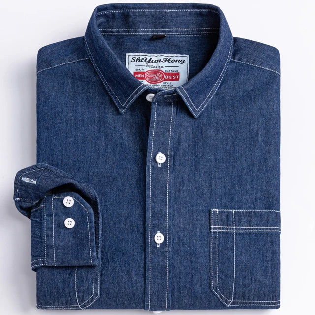 Folded blue denim shirt with brand label on a white background