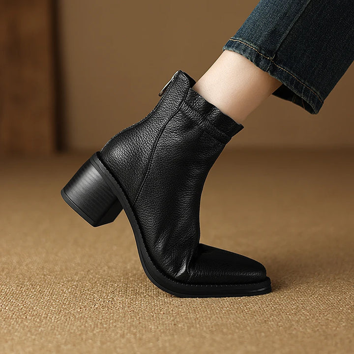 Black leather ankle boot on a brown background