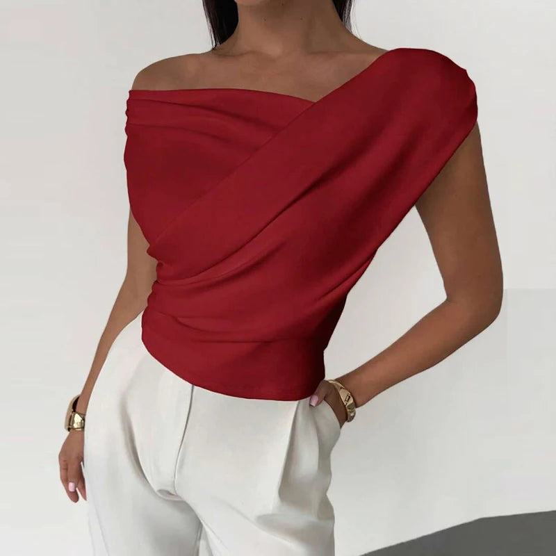 Red off-shoulder top worn by a person on a white background
