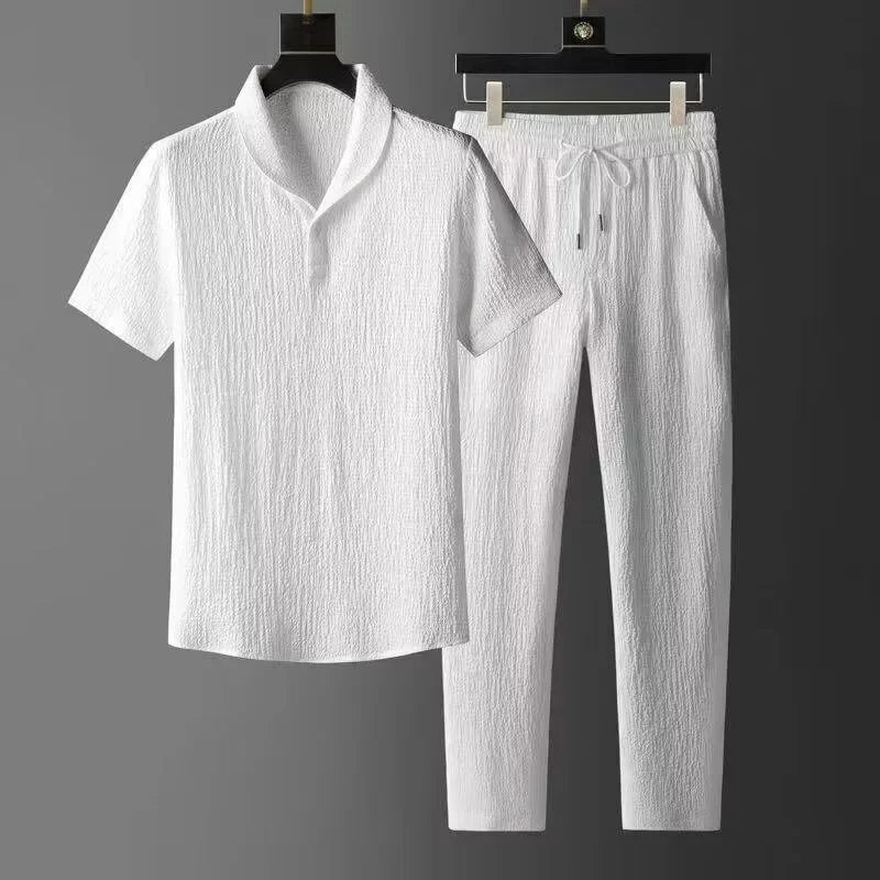 White textured shirt and pants set on hangers against a gray background
