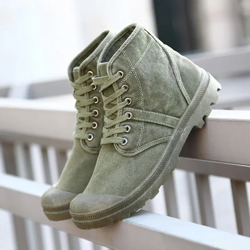 Pair of green suede boots on a white surface