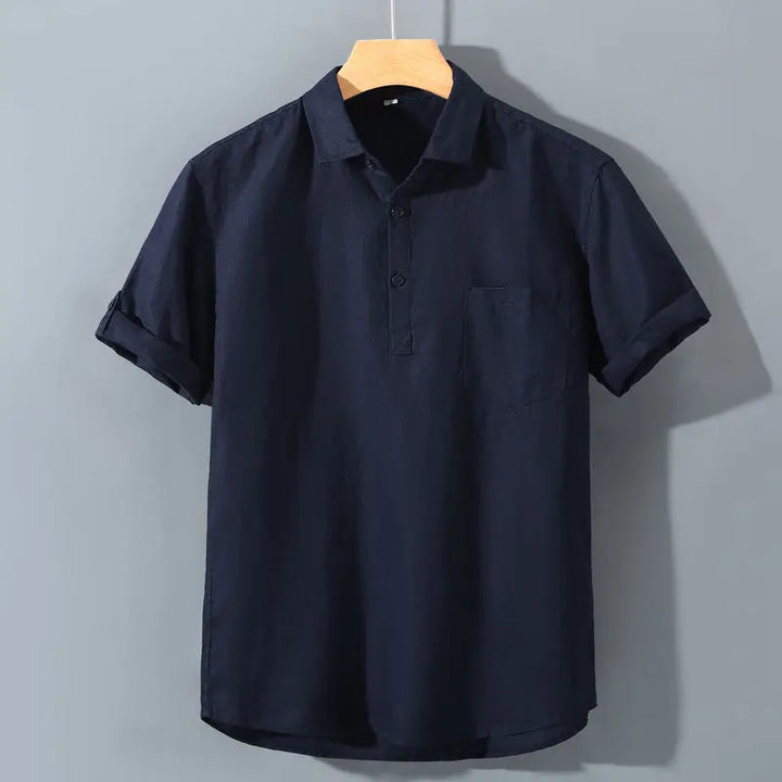 Navy blue polo shirt on a hanger against a gray background