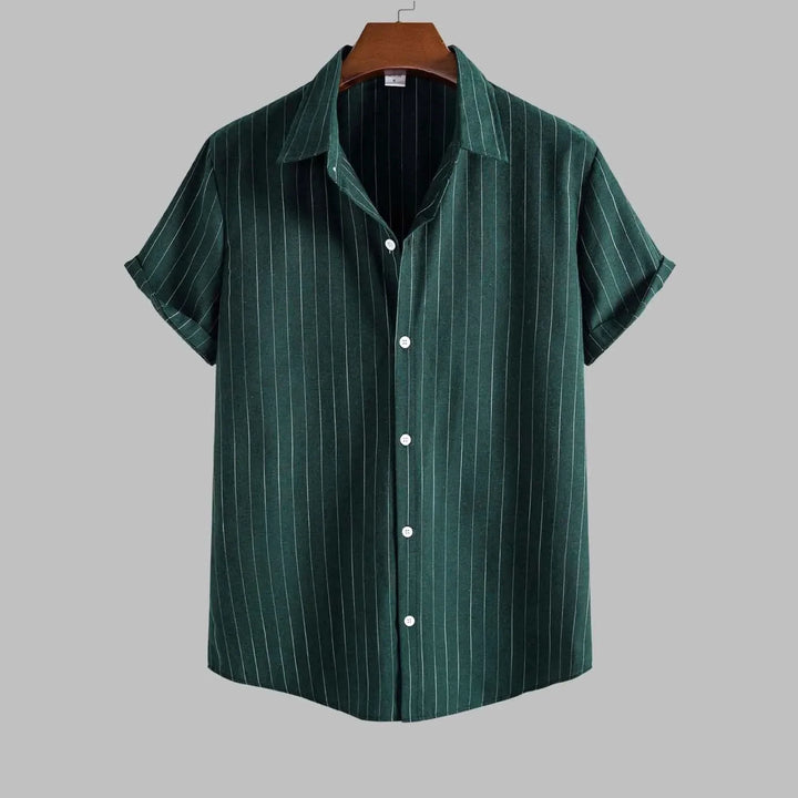 Green striped shirt on a hanger against a gray background