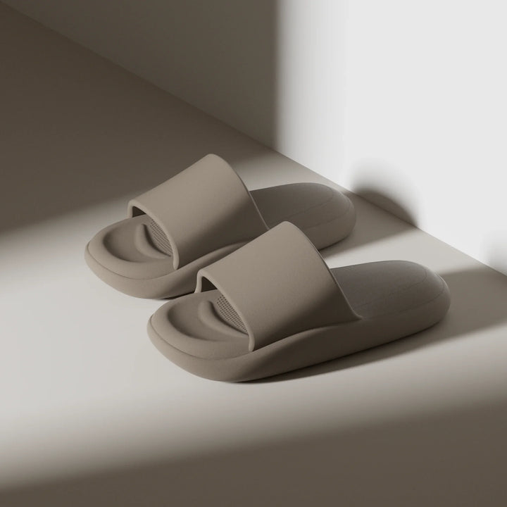 Pair of beige slippers on a light surface with a soft shadow