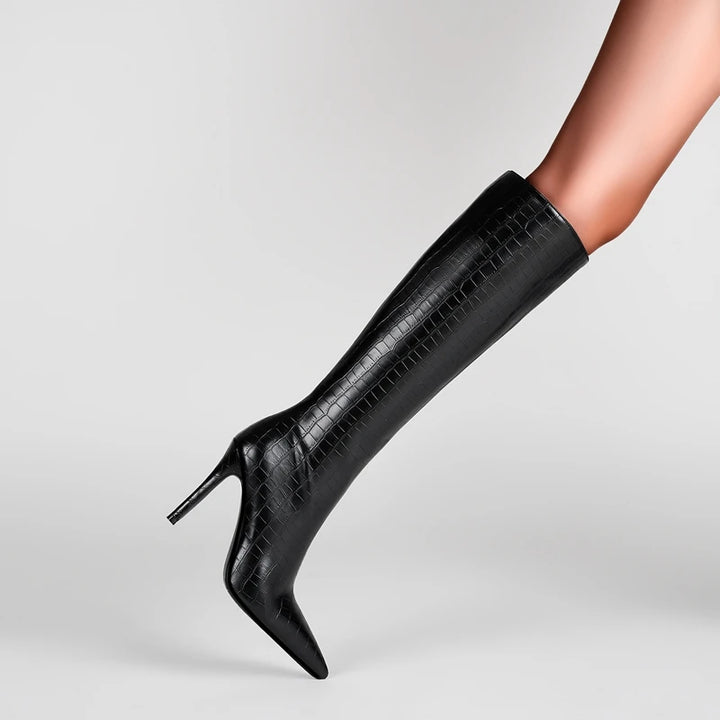 Black knee-high boot with high heel on a light gray background