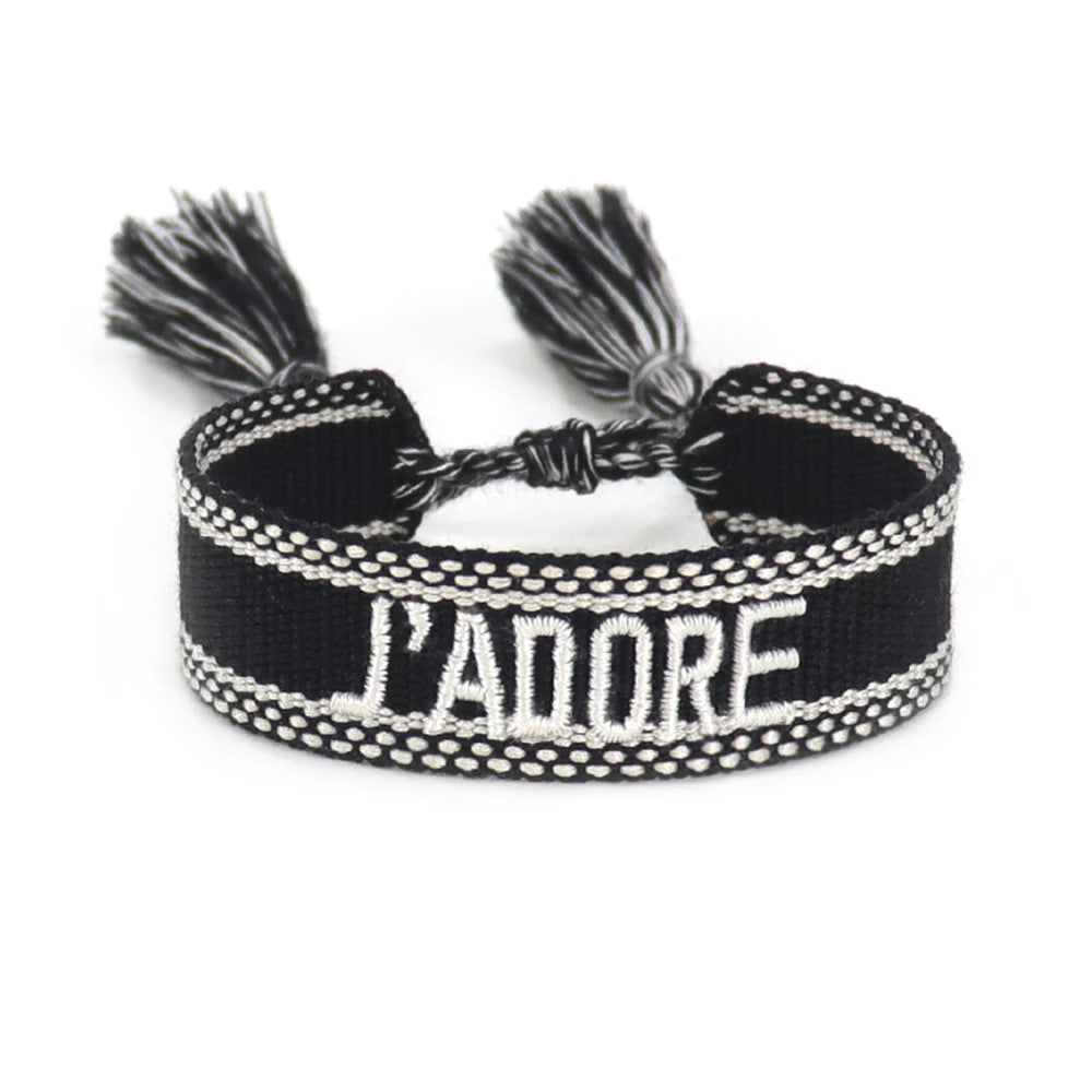 Black and white braided bracelet with 'L'ADORE' text on a white background