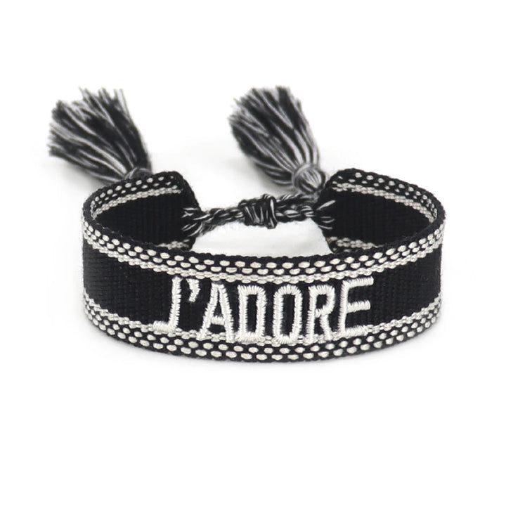 Black and white braided bracelet with 'L'ADORE' text on a white background