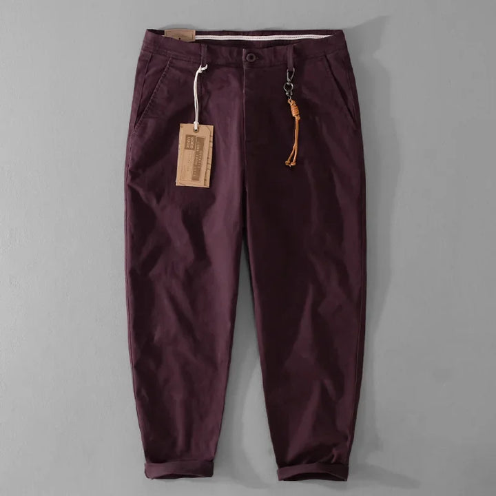Maroon pants with a tag on a gray background