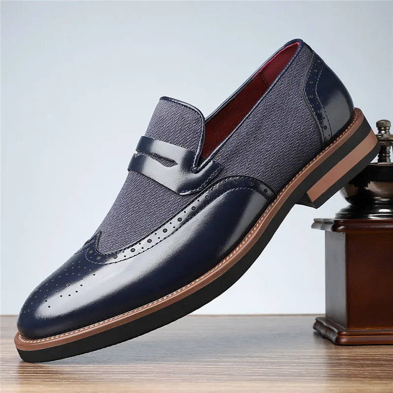 Navy blue leather loafer with brown sole on a light gray background