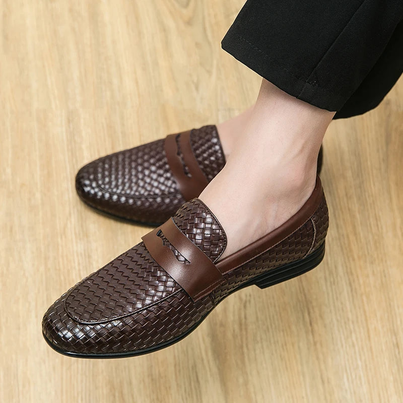 Brown woven loafers worn on a wooden floor