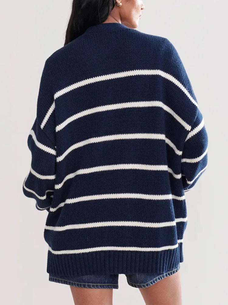 Navy and white striped sweater worn by a person on a plain background