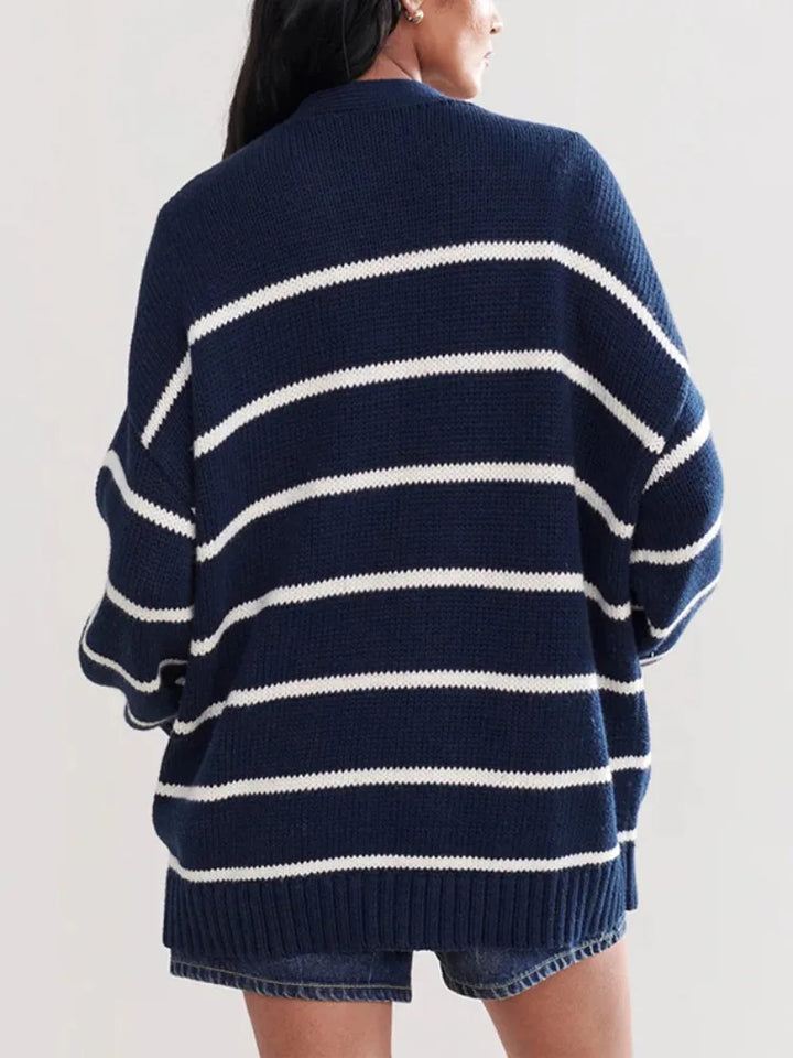 Navy and white striped sweater worn by a person on a plain background