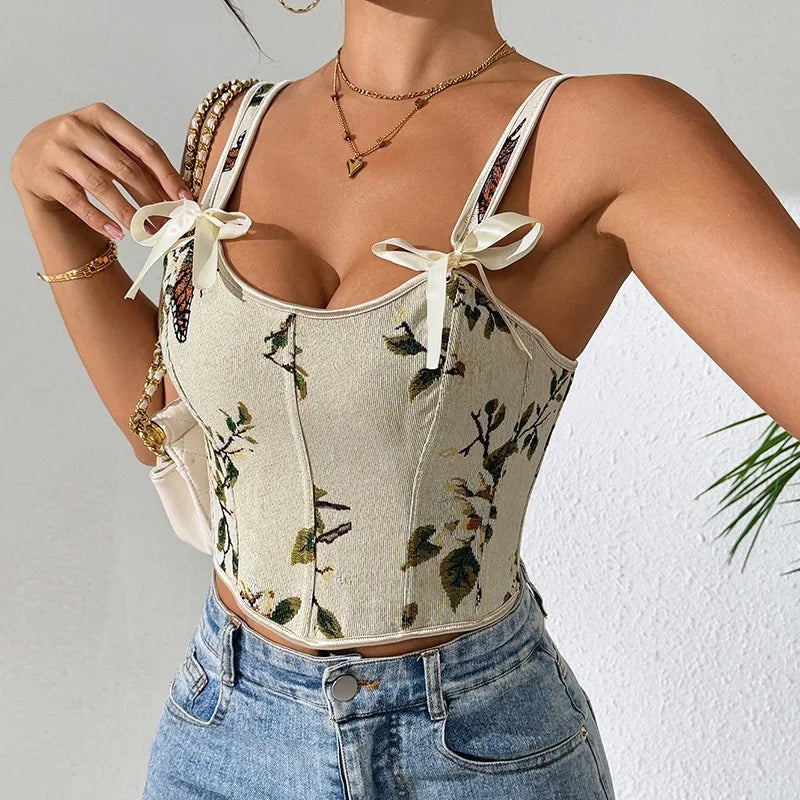 Person wearing a floral corset top and denim shorts against a neutral background