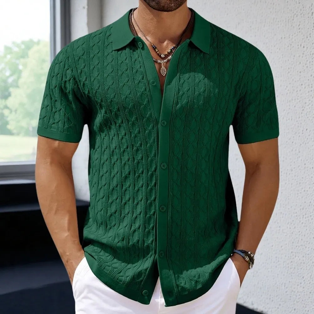 Man wearing a green textured shirt with white pants indoors.