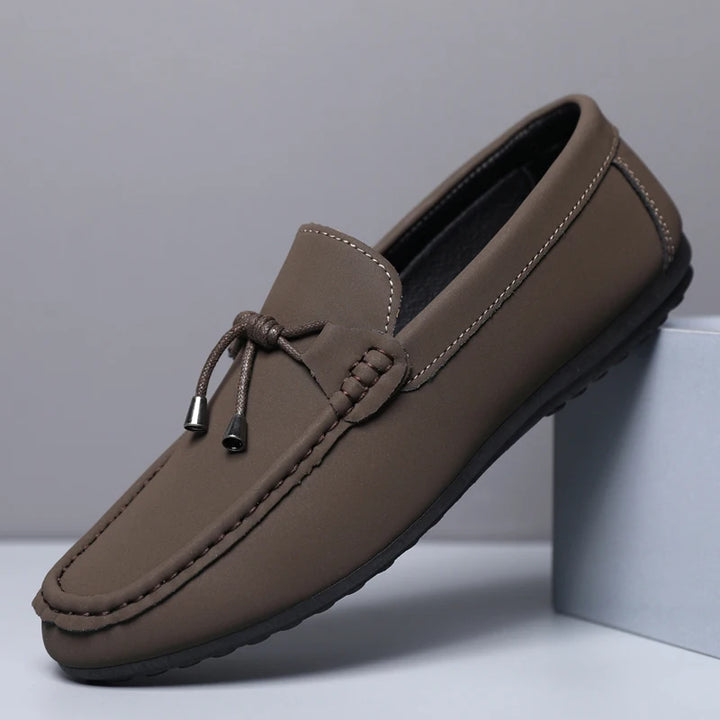 Brown loafer shoe on a light gray background