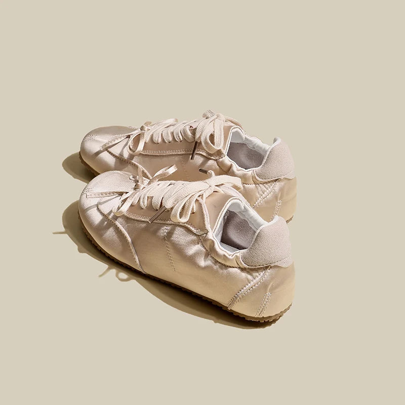 Pair of pink sneakers on a light beige background