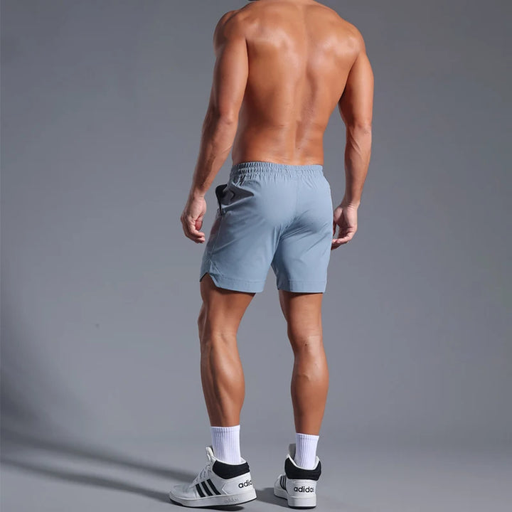 Man wearing light blue athletic shorts on a gray background