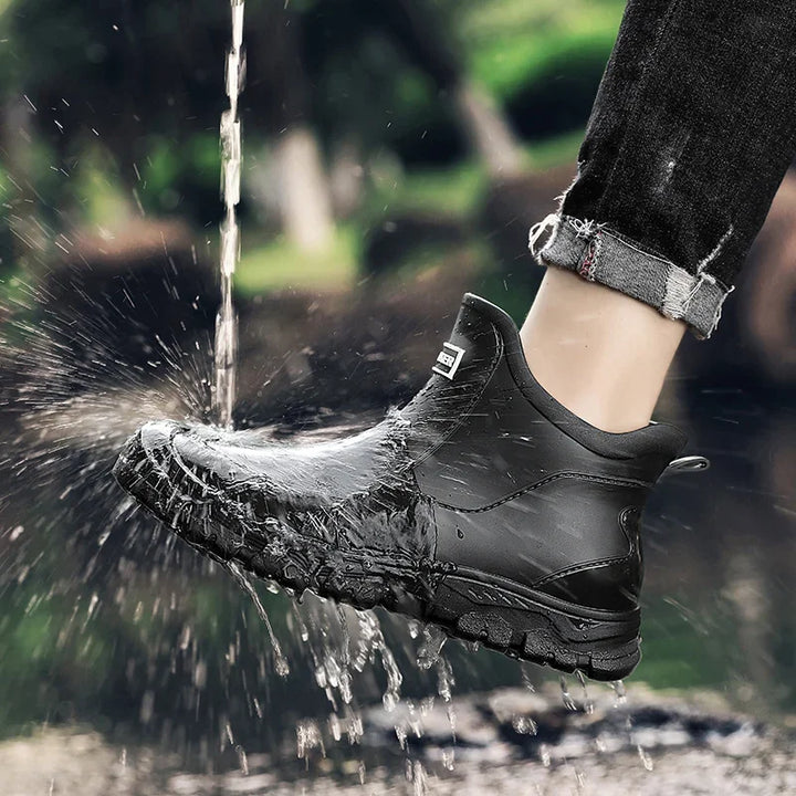 Black shoe splashing water outdoors with a blurred natural background