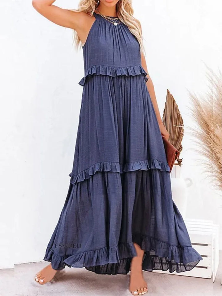 Navy blue tiered dress worn by a model on a white background