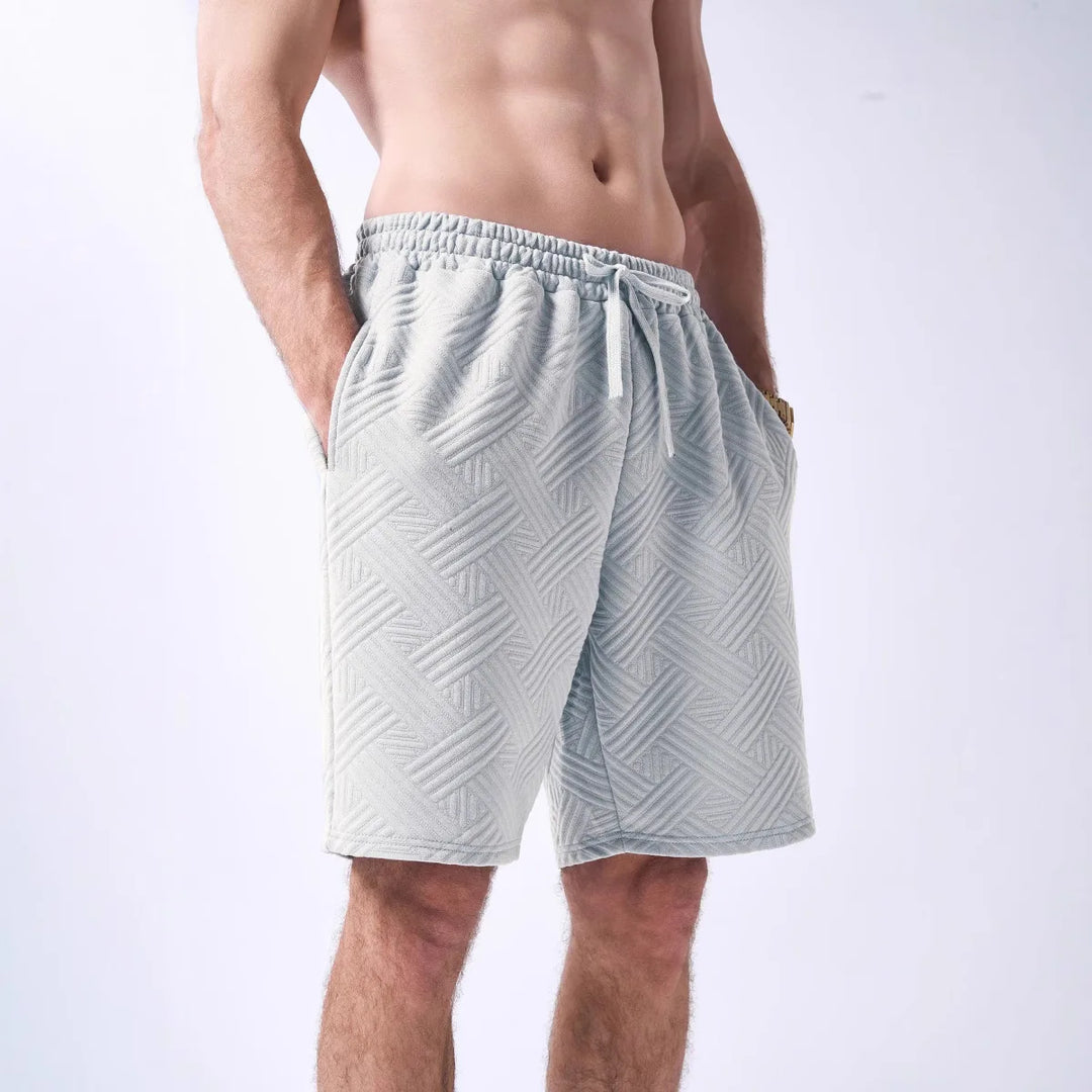 Light gray patterned shorts worn by a person on a white background