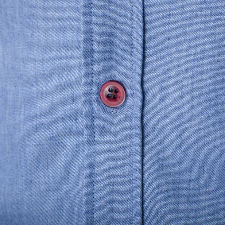 Close-up of a blue fabric shirt with a button