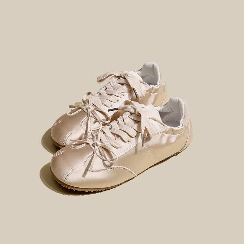 Pair of pink sneakers on a light beige background