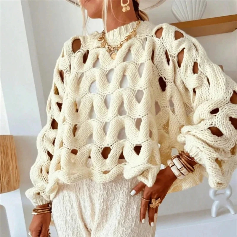 Person wearing a cream-colored knit sweater with a textured pattern.