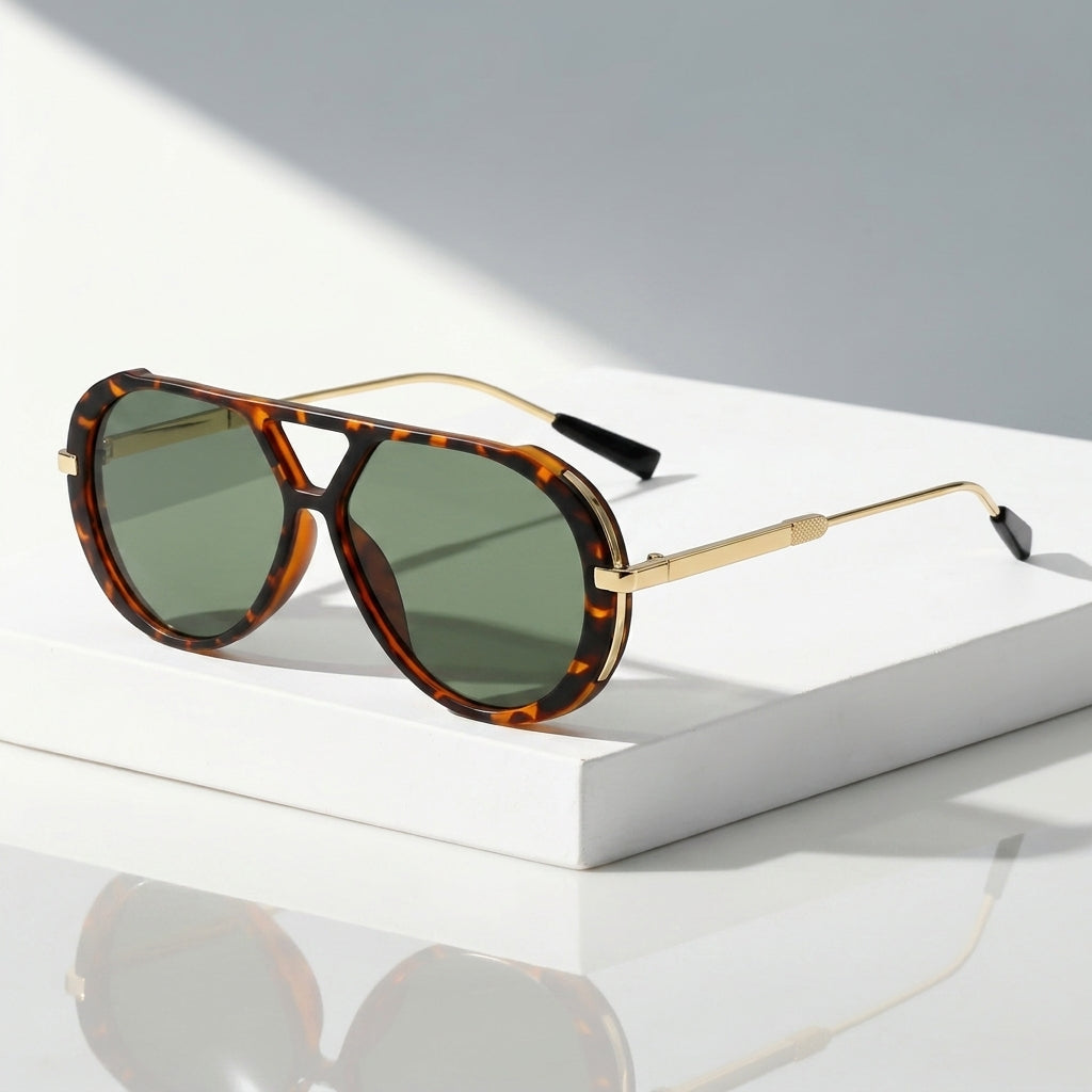 A pair of aviator-style sunglasses with tortoiseshell frames and green-tinted lenses, resting on a white rectangular display block against a light gray background.
